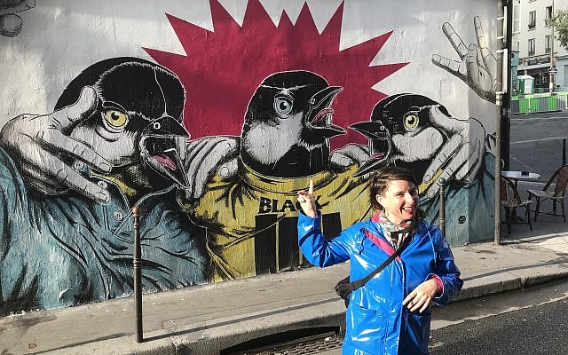 Shiry Avny giving details about a large mural during her street art tour. (Robert Sarner/ Times of Israel)