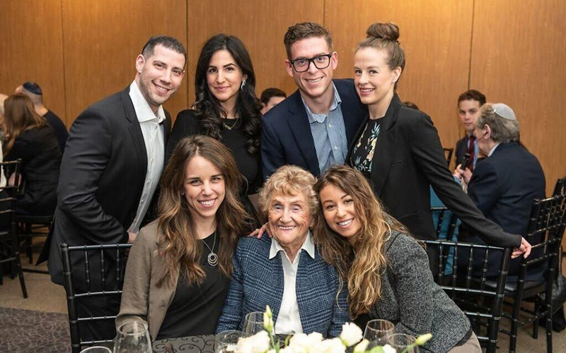 Holocaust survivor Rose Lipszyc, front center, and her granddaughter Brittney Hofbauer, front right, pose with table mates at the Dinner of Miracles in Toronto, December 15, 2019. (Liora Kogan)