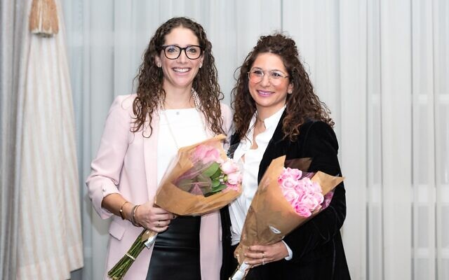 Dinner of Miracles co-founders Sherri Ettedgui, left, and Shawna Samuel receive flowers during a presentation at the Dinner of Miracles in Toronto, December 15, 2019.