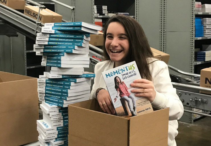 Hannah Alper holds up a copy of her book in her publisher’s warehouse on the day they were shipped out to bookstores, November 2017.