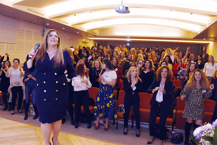 Orly Carmon, with microphone, at an Orca conference in Tel Aviv, 2019. (Photo by Miri Gattenyo)