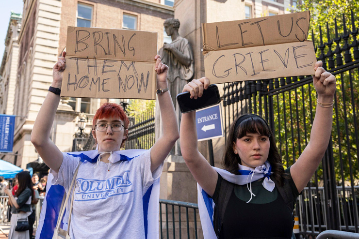 Freshman Shoshana Aufzien, right, and a friend raise signs while counter-protesting as pro-Palestinian supporters picket outside Columbia University, Tuesday, Sep. 3, 2024, in New York. (AP/Yuki Iwamura)