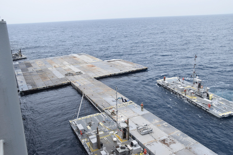 Soldiers assigned to the 7th Transportation Brigade (Expeditionary) and sailors attached to the MV Roy P. Benavidez assemble the Roll-On, Roll-Off Distribution Facility (RRDF), or floating pier, off the shore of Gaza in the Mediterranean Sea on April 26, 2024. (US Army via AP)