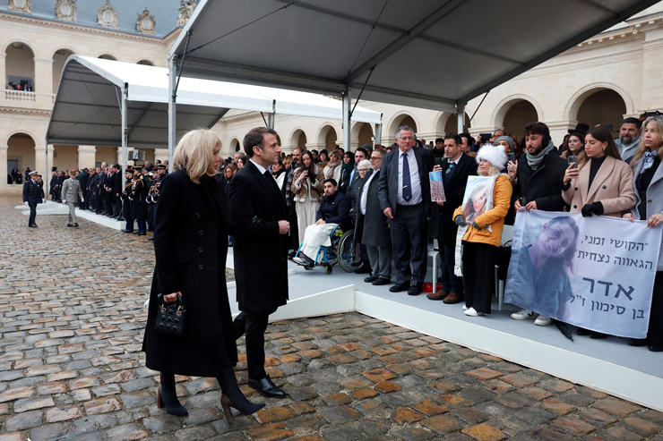 French President Emmanuel Macron and his wife Brigitte Macron arrive to host a ceremony to pay tribute to the French victims of the October 7, 2023, Hamas atrocities, at the Invalides memorial complex in Paris, on February 7, 2024.