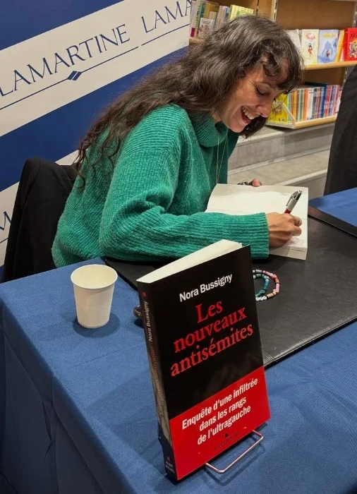 Nora Bussigny signs copies of her new book, ‘Les Nouveaux Antisemites,’ at Lamartine bookstore in Paris. (Courtesy of Bussigny)